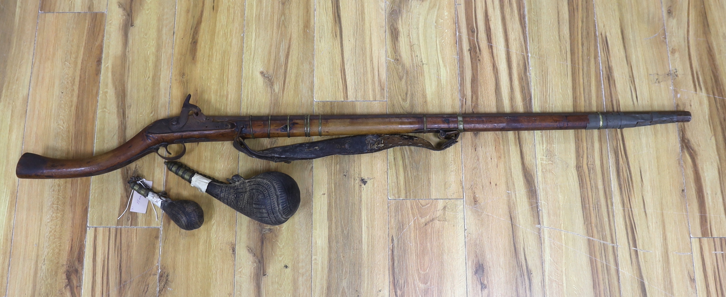 An Afghan percussion rifle and two shot flasks, rifle 143cm